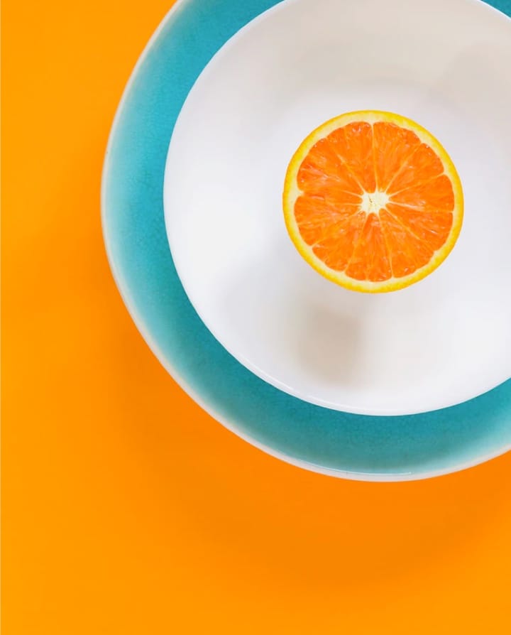 a plate with an orange sliced in half