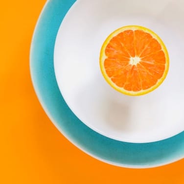 a plate with an orange sliced in half